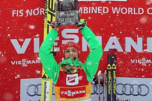 Eric Frenzel auf dem Siegerpodest: strahlend hält er den großen Pokal als Sieger des Seefeld Triples über den Kopf.